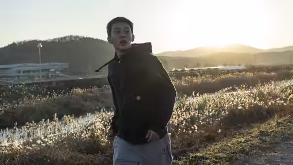 Lee Jong-su (Yoo Ah-in) stands on a rural path at sunset