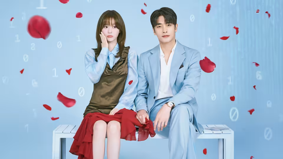 A woman and a man sit together on a white bench as red petals drift around them