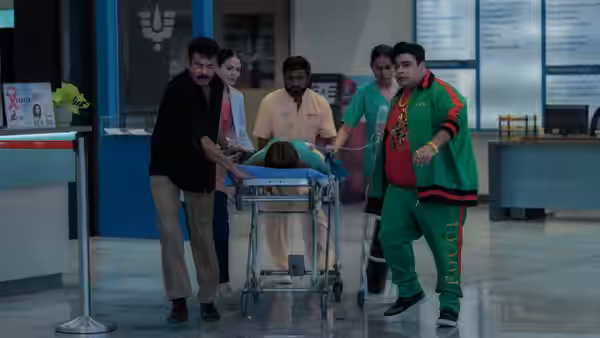 A group of people rushes a patient on a stretcher through a hospital lobby