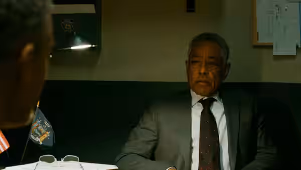 Detective Warren (Giancarlo Esposito) sits behind a desk in a police office