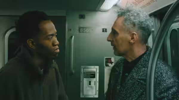 Two men face each other inside a subway car