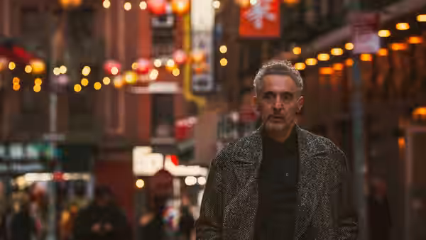 Harry (John Turturro) walks along a crowded street at night