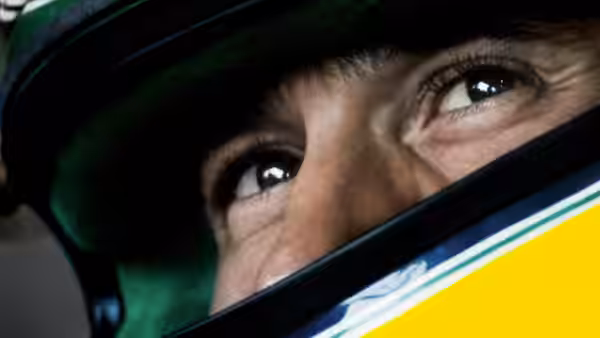close up of a driver's eyes beneath a green helmet