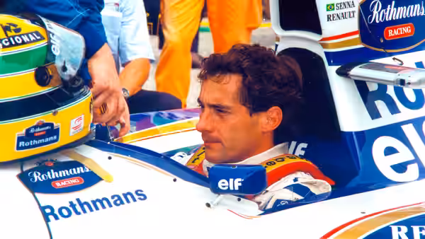 Ayrton Senna in racing suit sitting in a formula one car