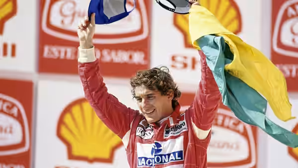 Ayrton Senna waving a Brazilian flag on the podium