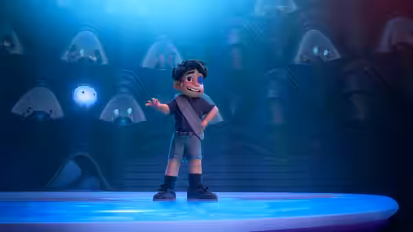 Elio (Yonas Kibreab) standing on a blue platform gesturing in a futuristic chamber