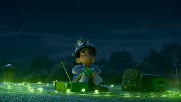 Elio (Yonas Kibreab) sitting on grass amid glowing equipment and lights at night