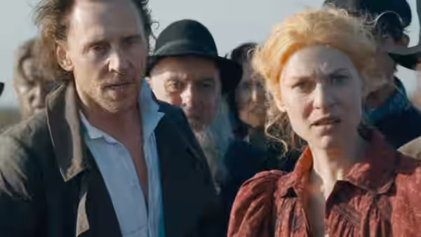 Will Ransome (Tom Hiddleston) and Cora Seaborne (Claire Danes) stand among a crowd outdoors