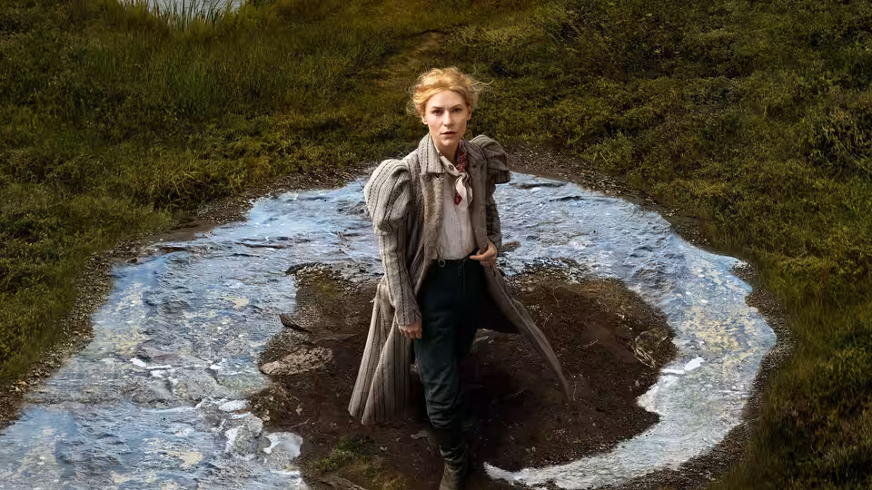 Cora Seaborne (Claire Danes) stands in a muddy clearing surrounded by a ring of water