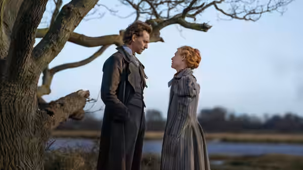 Will Ransome (Tom Hiddleston) and Cora Seaborne (Claire Danes) face each other beneath a tree