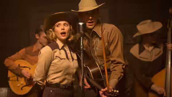 Audrey Mae Williams (Elizabeth Olsen) and Hank Williams (Tom Hiddleston) sing together onstage in cowboy hats