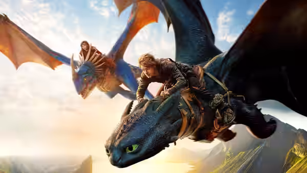 Two people ride dragons over mountains under a partly cloudy sky