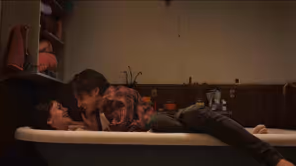 Charlie (Nick Robinson) leans over Harper (Emilia Jones) as she lies in a bathtub