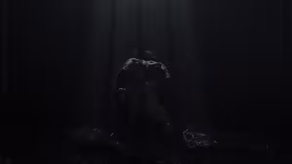 A hunched figure crouches alone among trees in a dark forest