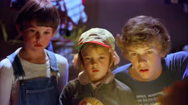 Elliott (Henry Thomas) Gertie (Drew Barrymore) and Michael (Robert MacNaughton) standing together