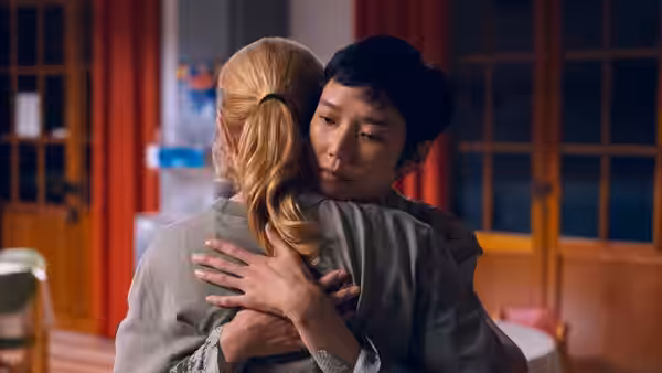 Mari Morisaki (Tao Okamoto) embraces Marie Lou-Fontaine (Virginie Efira) in a warmly lit room