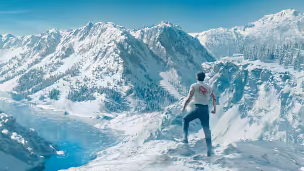 A man stands alone on a snowy ridge above a frozen mountain valley