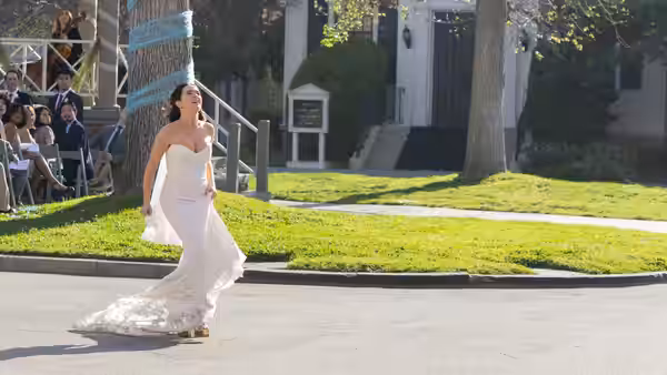 Gail Daughtry (Zoey Deutch) runs across a street in a wedding dress