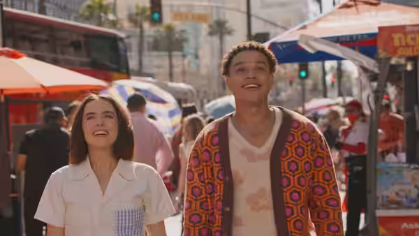 Gail Daughtry (Zoey Deutch) and a young man stroll through a crowded market