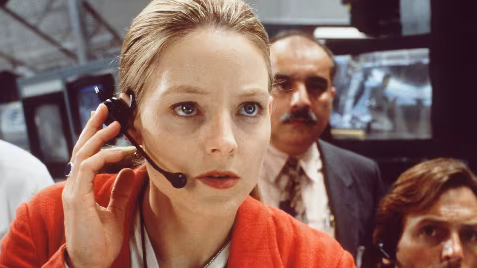 Ellie Arroway (Jodie Foster) speaking into her headset in a busy control room