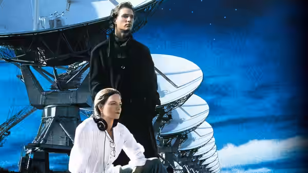 Ellie Arroway (Jodie Foster) and Palmer Joss (Matthew McConaughey) by a large radio telescope