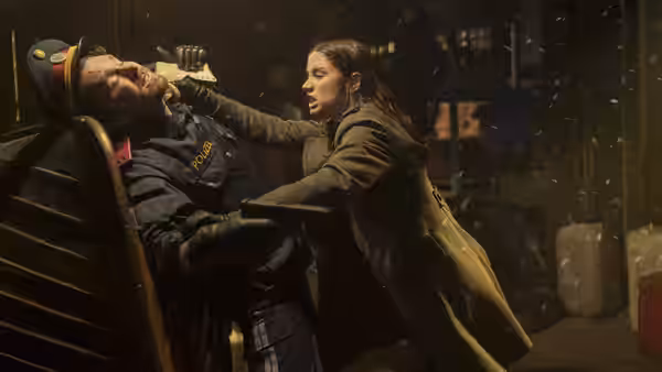 Eve (Ana de Armas) grabbing a police officer by the face in falling snow