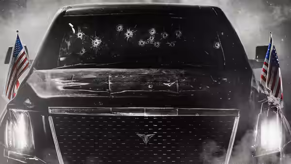 A bullet-riddled presidential limousine bearing American flags