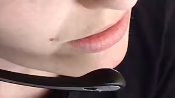 A close view of a person's lips above a black choker