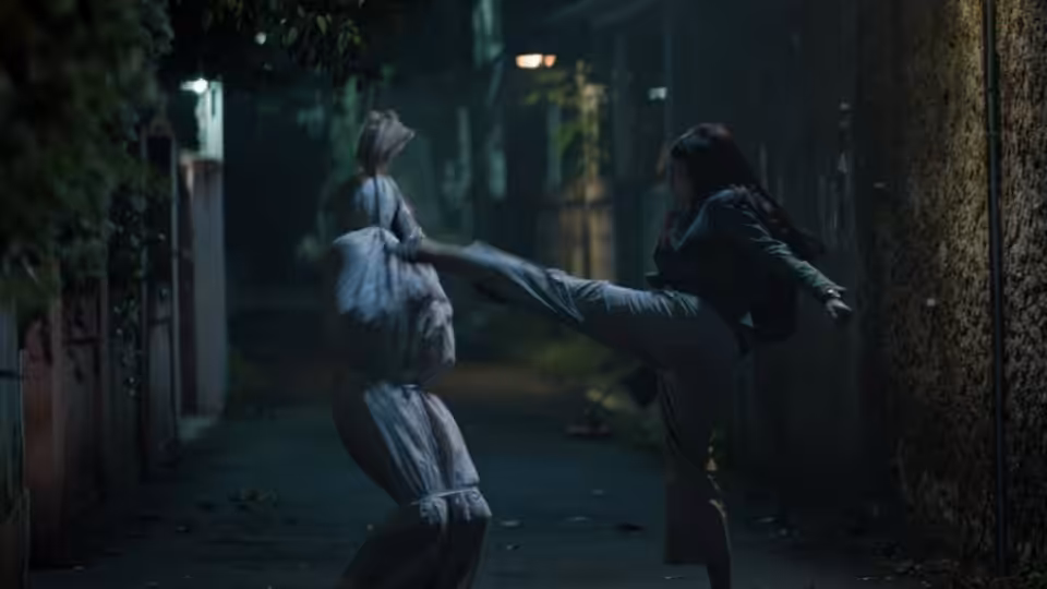 A person kicks a bundled figure along a dim, narrow alley
