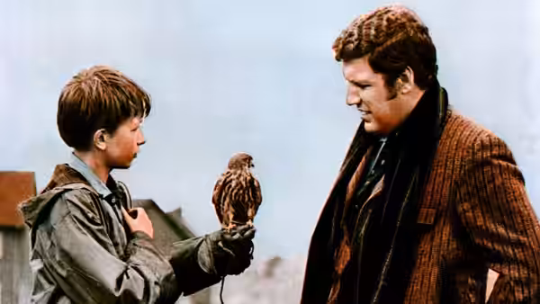 Billy (Dai Bradley) shows his kestrel to a man in a striped jacket