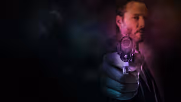 John Wick (Keanu Reeves) aiming a revolver straight at the camera