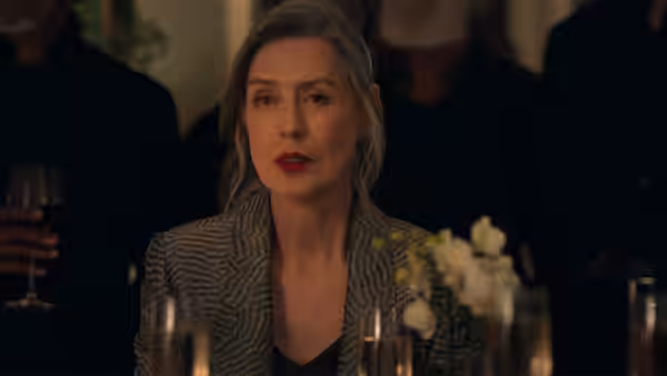 Hannah Carmichael (Gina McKee) sits at a formal dinner table