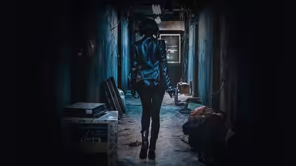 A woman in a leather jacket walks through a dark corridor past fallen figures