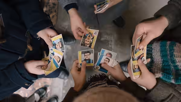Children gather around, sorting and swapping illustrated football player stickers