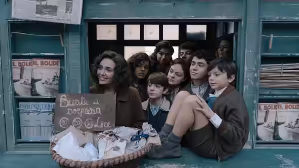 A young woman and children crowd a shop window around a basket and handwritten sign