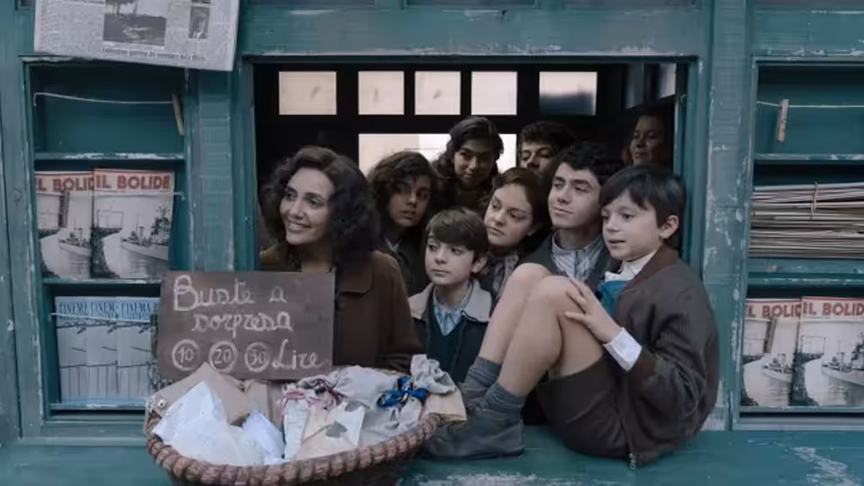 A young woman and children crowd a shop window around a basket and handwritten sign