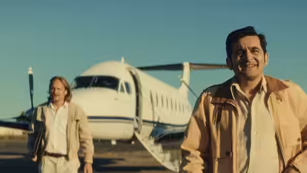 Léo Sarda (Karim Leklou) walks past a private jet as Arnaud de Toledo approaches