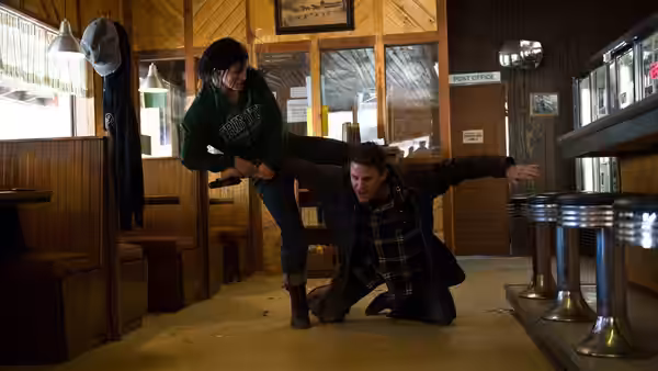 Mallory Kane (Gina Carano) kicking a man across the floor of a diner