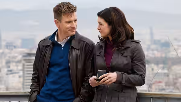 A man and Mallory Kane (Gina Carano) standing together on a city overlook