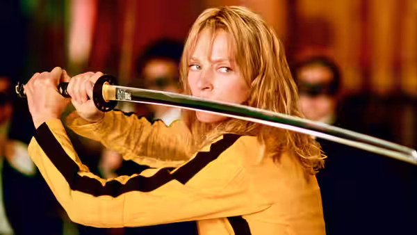 The Bride (Uma Thurman) grips katana blade with focused expression