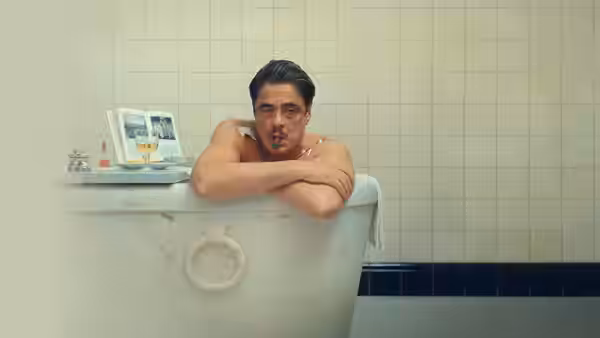 Zsa-zsa Korda (Benicio del Toro) resting arms on a marble bathtub edge