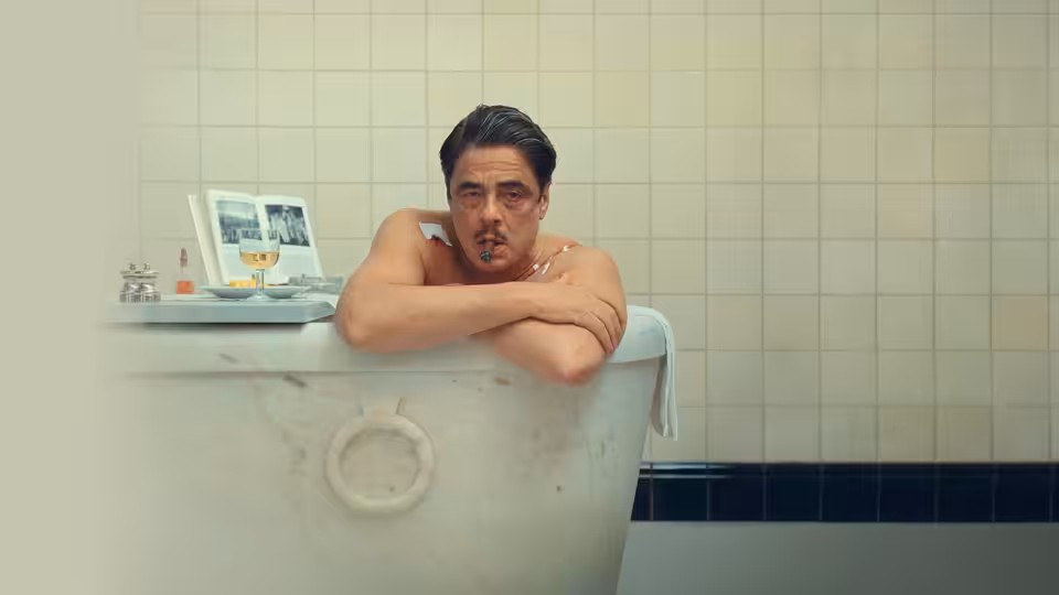 Zsa-zsa Korda (Benicio del Toro) resting arms on a marble bathtub edge