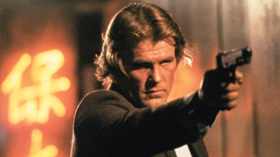 Jack Cates (Nick Nolte) aims a handgun in a neon-lit street