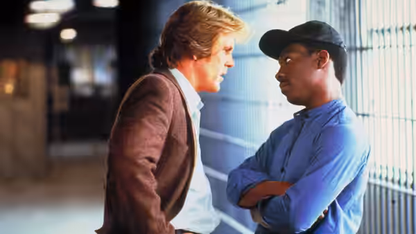Jack Cates (Nick Nolte) faces Reggie Hammond (Eddie Murphy) beside barred windows