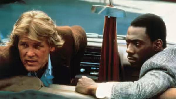 Jack Cates (Nick Nolte) and Reggie Hammond (Eddie Murphy) lean across a car interior