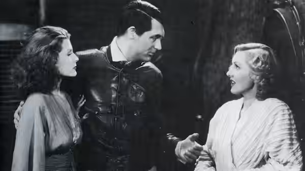 Geoff Carter (Cary Grant) talks with Bonnie Lee (Jean Arthur) as another woman watches