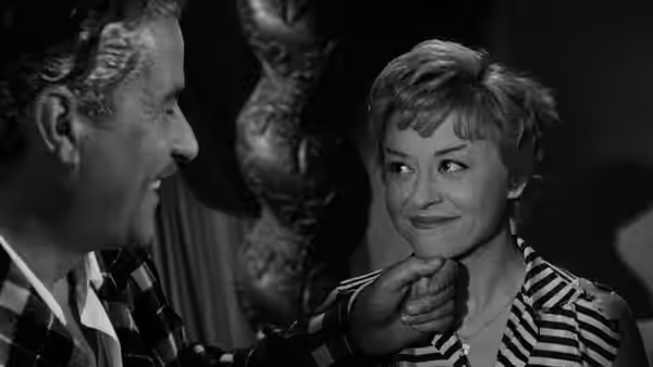 A man touches Cabiria’s (Giulietta Masina) chin as she smiles at him