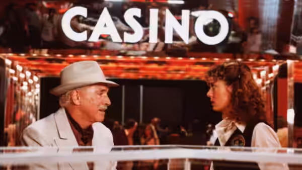 Lou (Burt Lancaster) talking with Sally (Susan Sarandon) beneath a casino sign