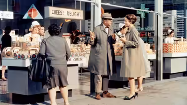 Monsieur Hulot (Jacques Tati) talks with a woman beside a cheese counter
