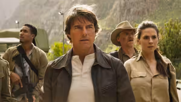 Ethan Hunt (Tom Cruise) with companions standing in rugged terrain